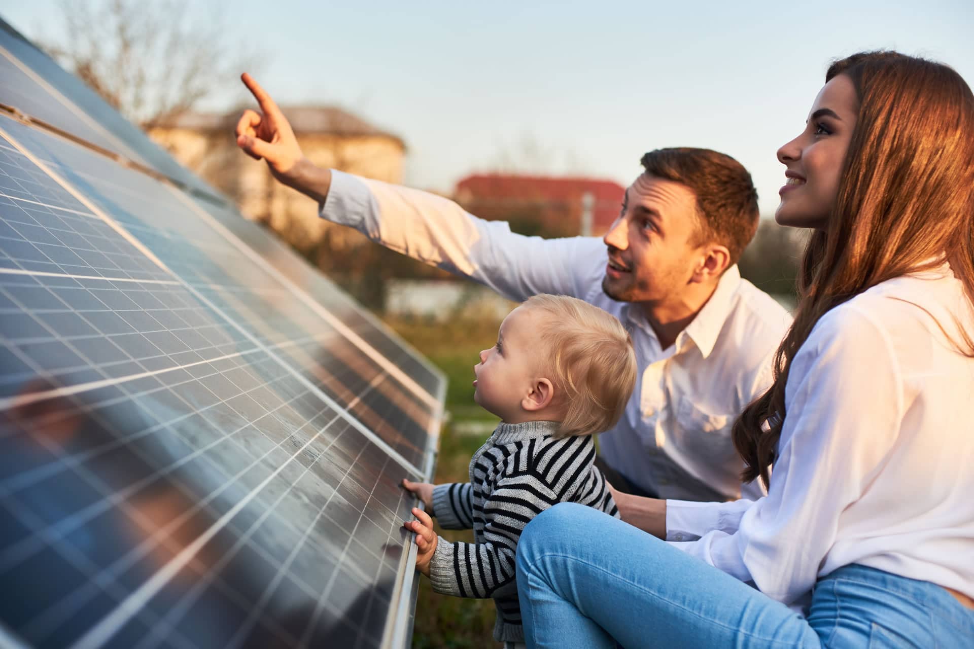 Familie steht begeistert vor einer Photovoltaikanlage