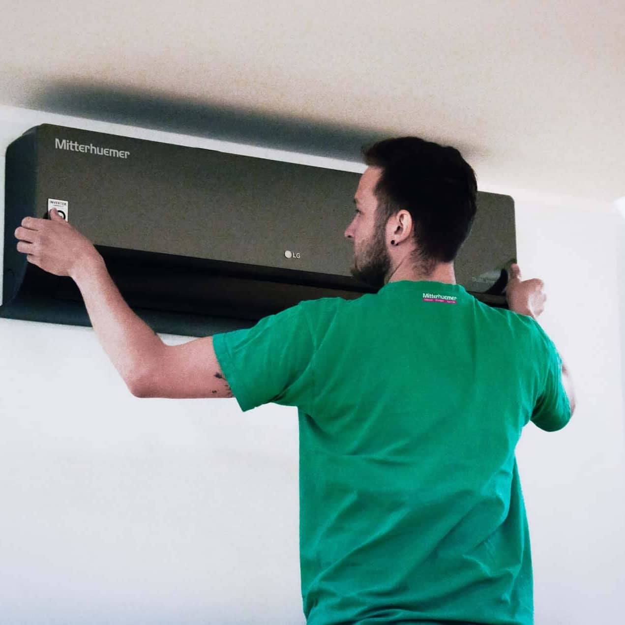 Mitterhuemer Mitarbeiter montiert eine Klimaanlage